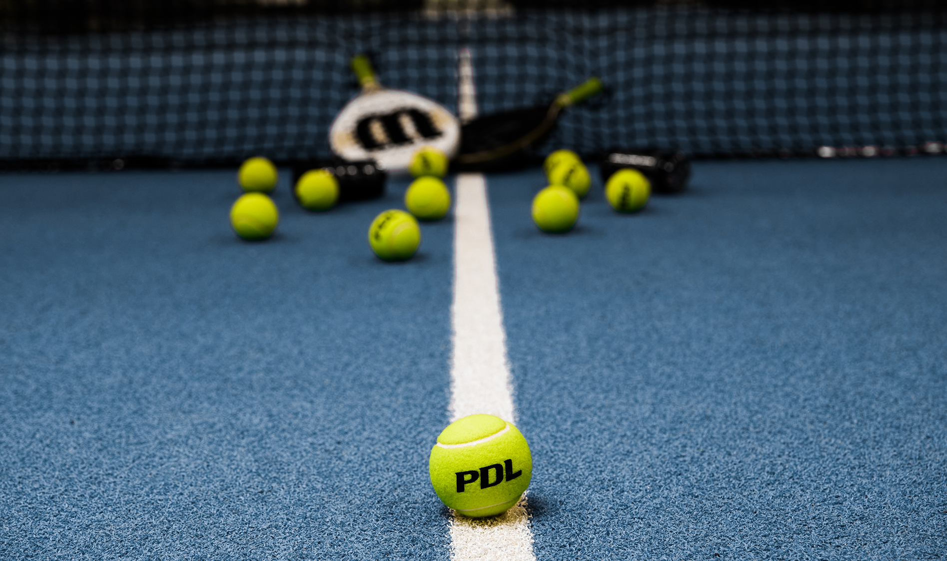 Tennis ball with PDL branding on a tennis court